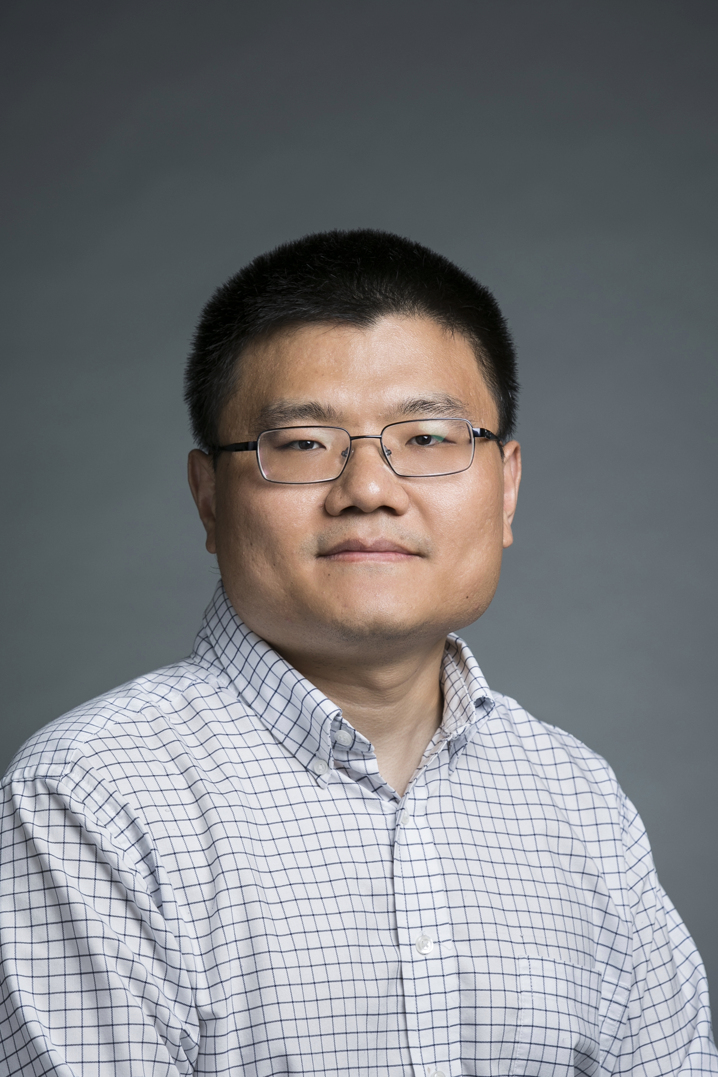 Wanli Qiao, Mason statistics professor, wears a light, long-sleeve shirt and glasses in his faculty profile